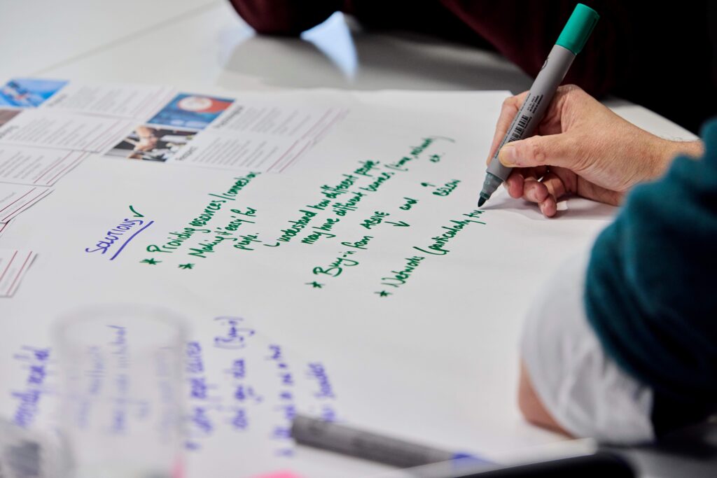 An attendee writes on a flipchat sheet